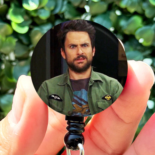 a person holding a keychain with a picture of a man on it