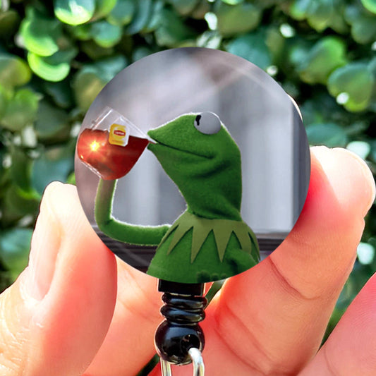 a person holding a key chain with a kermie the frog on it