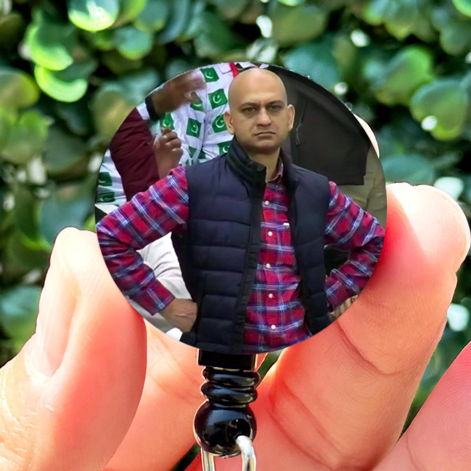 a person holding a keychain with a picture of a man on it