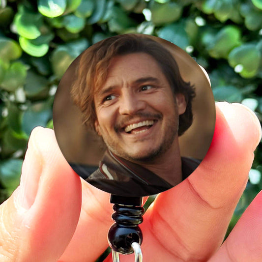 a person holding a key chain with a picture of a man on it