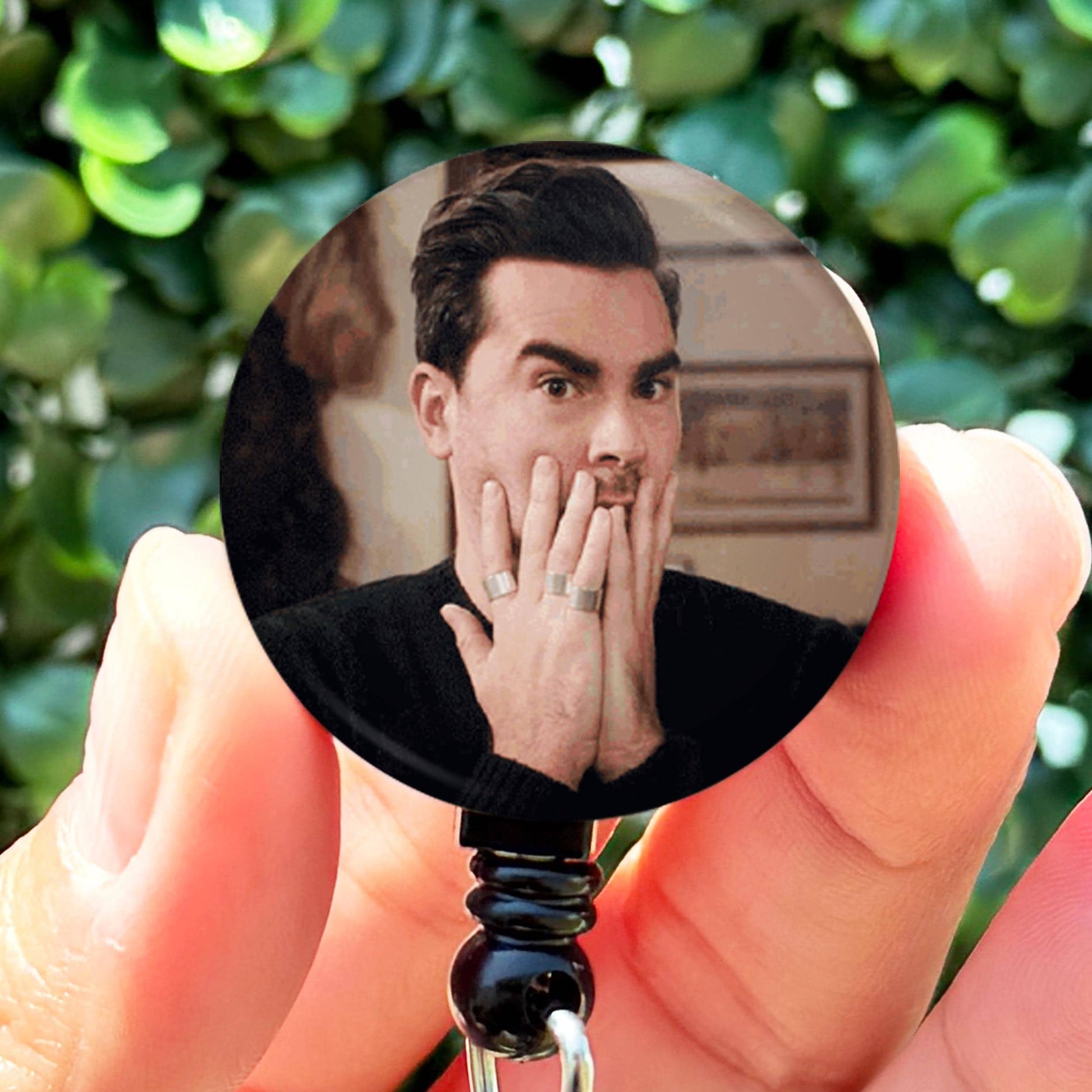 a person holding a badge with a picture of a man on it