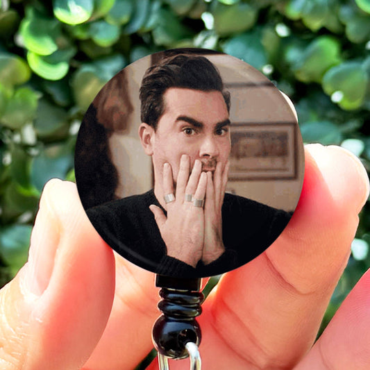 a person holding a badge with a picture of a man on it