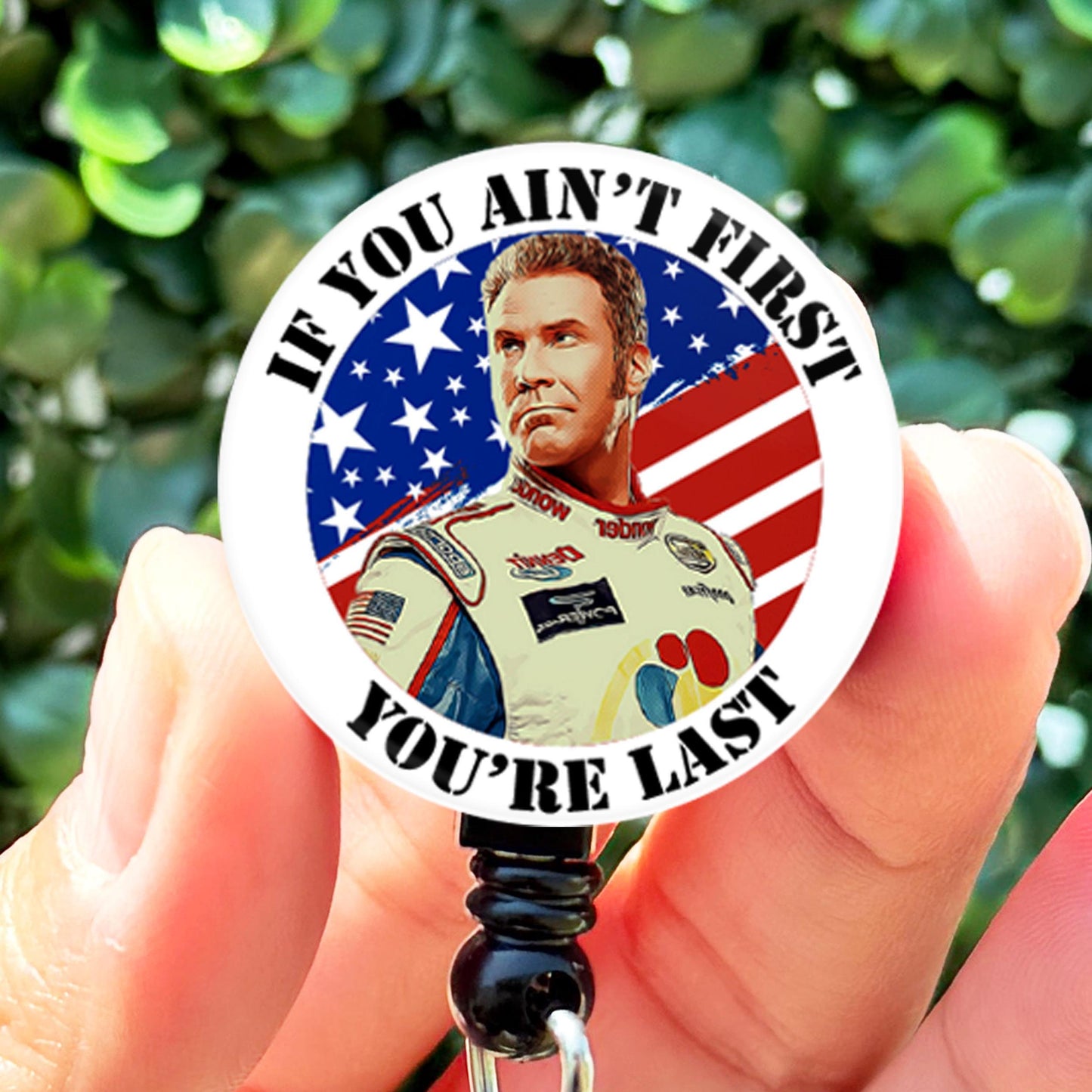 a person holding a badge with a picture of a man on it