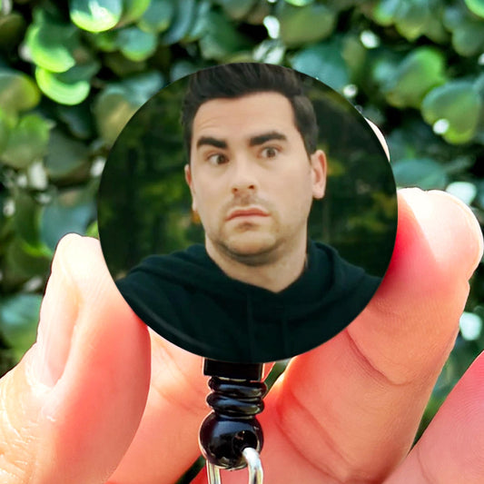 a man holding a key chain with a picture of him