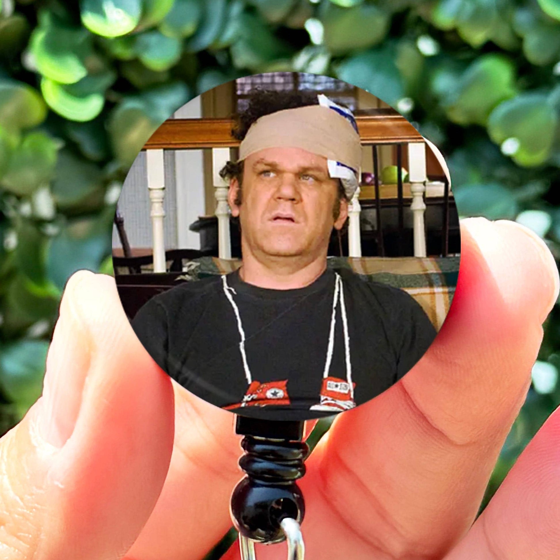 a man holding a key chain with a house in the background